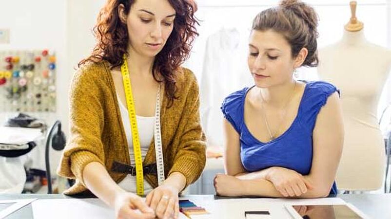Fit engineer teaching student with fabric swatches